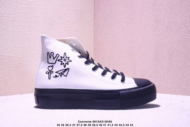 The same Converse thick-soled, height-enhancing white and black canvas shoes wor