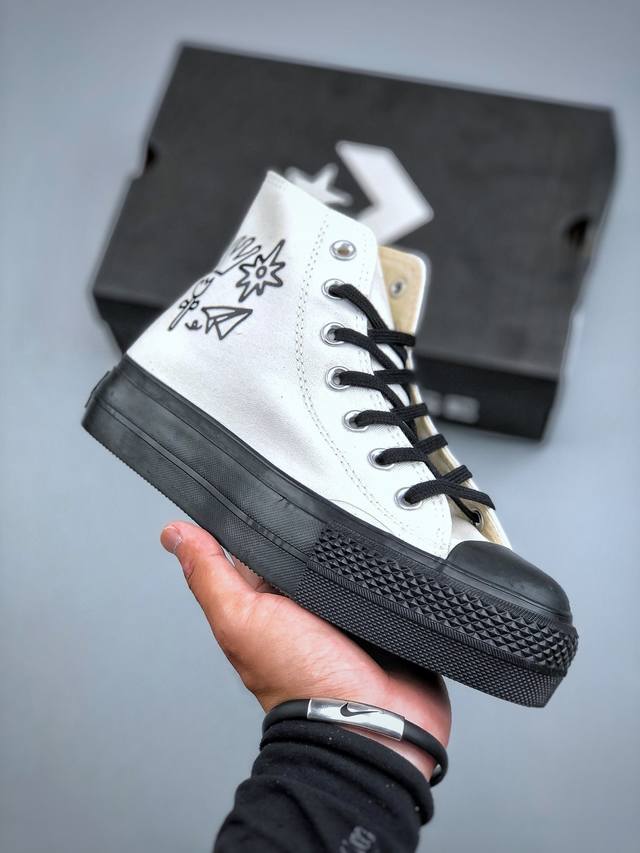 The same Converse thick-soled height-enhancing white and black canvas shoes worn