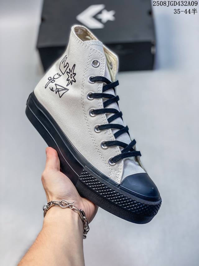 The same Converse thick-soled, height-enhancing white and black canvas shoes wor